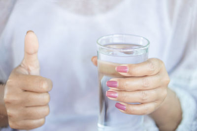 Close-up of hand holding glass of drink