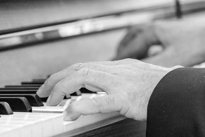 Cropped hands playing piano
