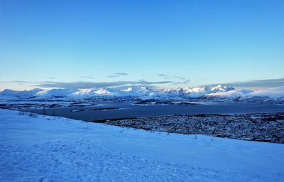 Scenic view of snowcapped mountains against blue sky