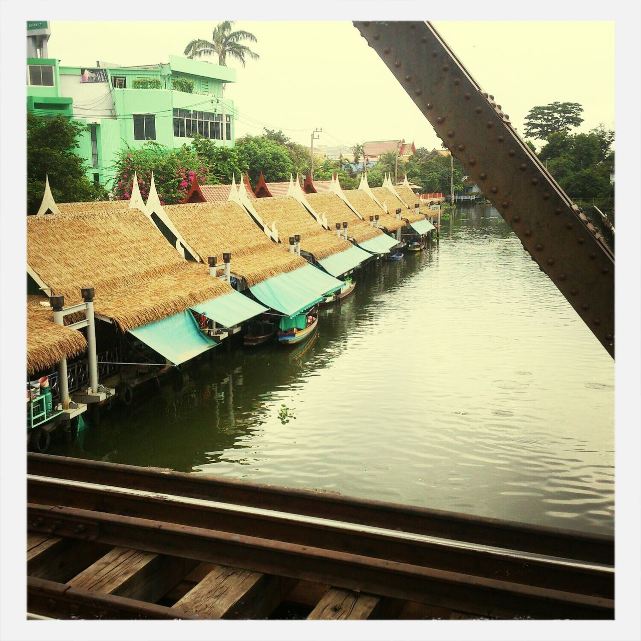 built structure, architecture, building exterior, water, transfer print, house, roof, residential structure, auto post production filter, canal, sky, residential building, day, river, pier, railing, outdoors, high angle view, wood - material, reflection