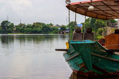 Boat moored in lake against sky