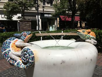 Statue by fountain against trees