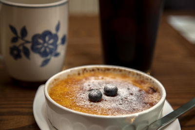 Close-up of pie with coffee in bowl on wooden table