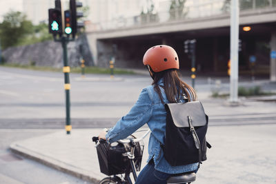 Rear view of woman cycling on street
