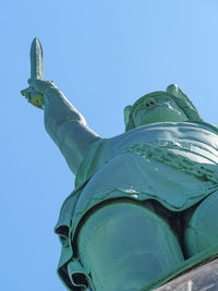 Low angle view of statue against clear blue sky