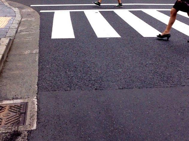 LOW SECTION OF MAN WITH UMBRELLA ON ROAD