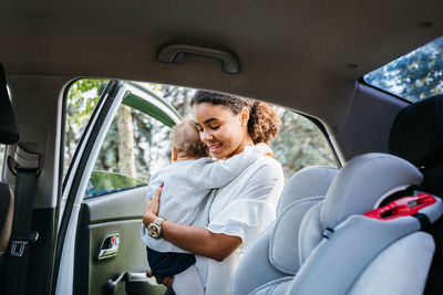 Young woman with girl entering car