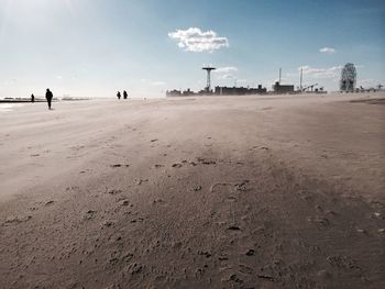 Man walking on beach against sky