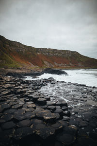 Surface level of rocks in river against sky