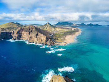 Scenic view of sea and mountains against sky