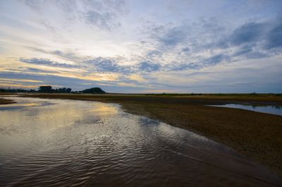 Scenic view of beach against sky during sunset