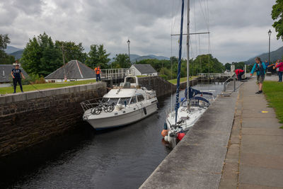 Boats moored in river against sky