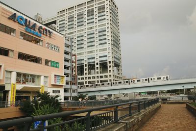 Footbridge over city against sky