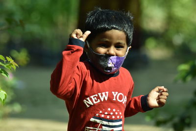 Portrait of boy wearing mask standing outdoors