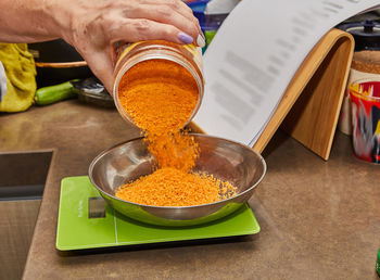 Cropped hand of woman holding food on table