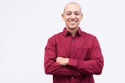 Portrait of young man standing against white background