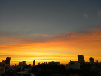 Silhouette buildings against sky during sunset