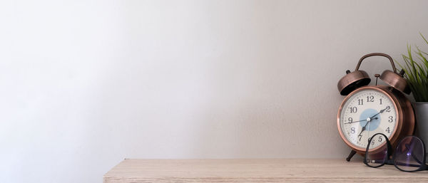 Clock on table against wall at home