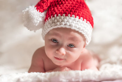 Portrait of cute baby boy lying on bed at home