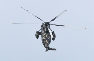 Low angle view of helicopter against clear sky