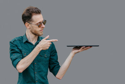 A young man gestures in the direction where the place for the inscription or banner is located