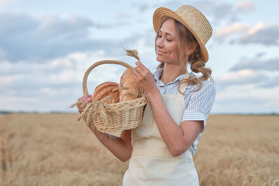 Midsection of woman wearing hat while standing on field