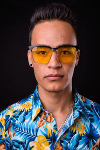 Portrait of young man against black background