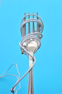Close-up of fork and headphones against blue background