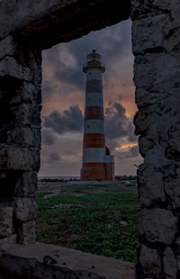 Low angle view of lighthouse amidst buildings against sky