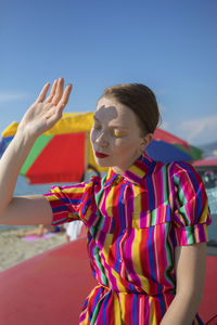 Midsection of woman at beach against sky