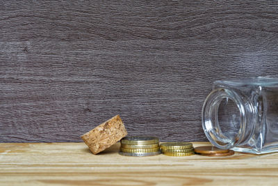 Close-up of coins by glass jar on table