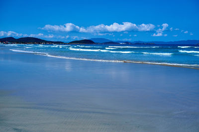 Scenic view of beach against blue sky