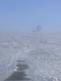 Frozen landscape against sky during winter