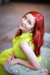 Portrait of smiling beautiful woman with redhead sitting on seat