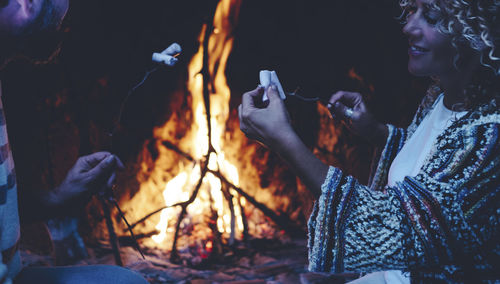 Smiling woman roasting marshmallows at home