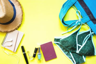 High angle view of personal accessories over yellow background