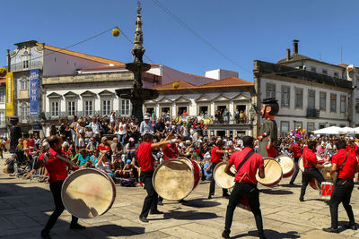 People on street against buildings in city