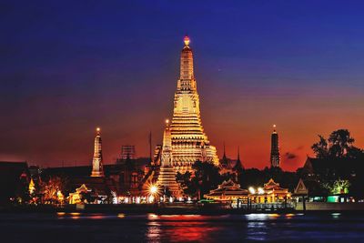 Illuminated wat arun temple at sunset