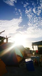 People sitting on table against bright sun during sunset