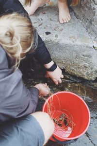 High angle view of male friends crab fishing on rock at shore