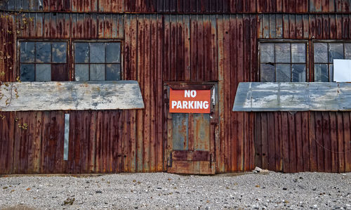 No parking sign on closed door of abandoned building