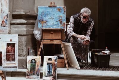 Man using mobile phone while sitting at workshop