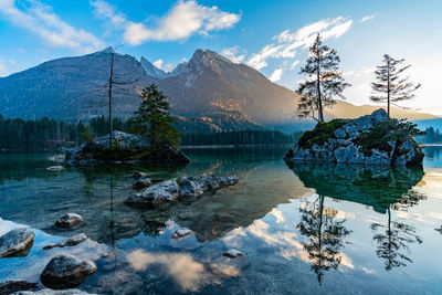 Scenic view of lake by snowcapped mountains against sky