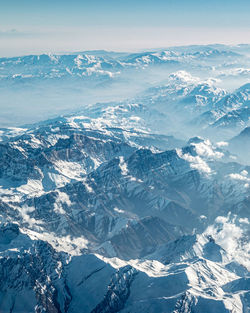 Aerial view of snowcapped mountains against sky