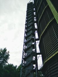 Low angle view of modern building against cloudy sky