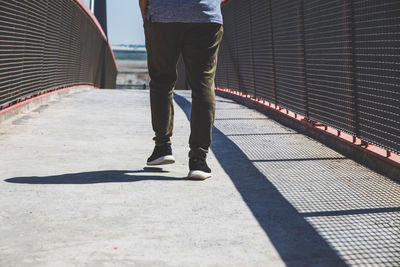 Low section of man walking on bridge