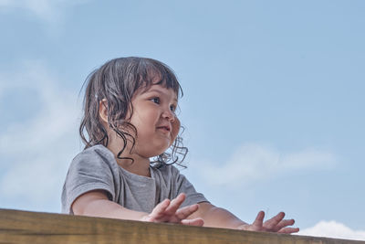Portrait of cute girl looking away against sky