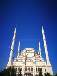 Low angle view of sabanc? central mosque against blue sky