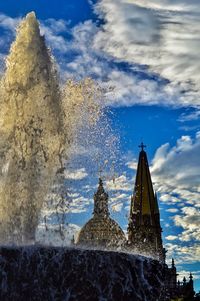 Low angle view of temple against cloudy sky