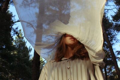 Girl's face covered by the white fabric